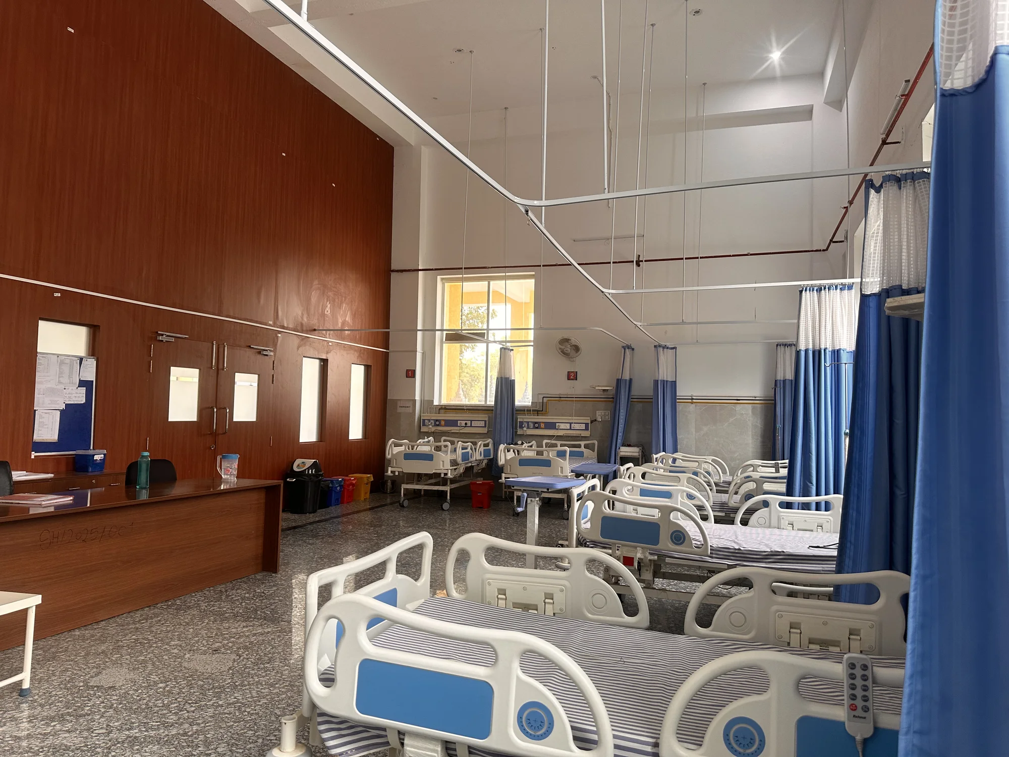 Hospital ward with patient beds and privacy curtains