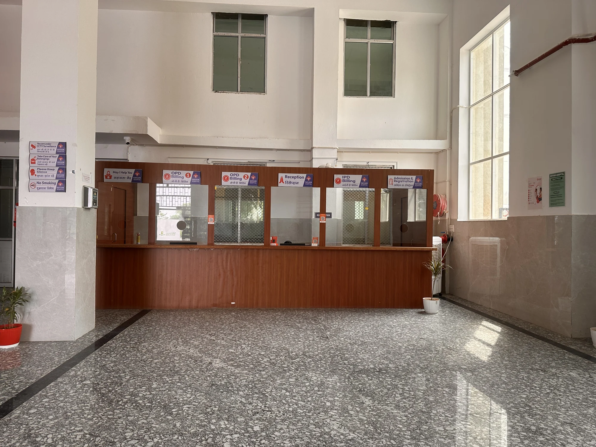 Hospital OPD and reception counters across the bright entrance hall