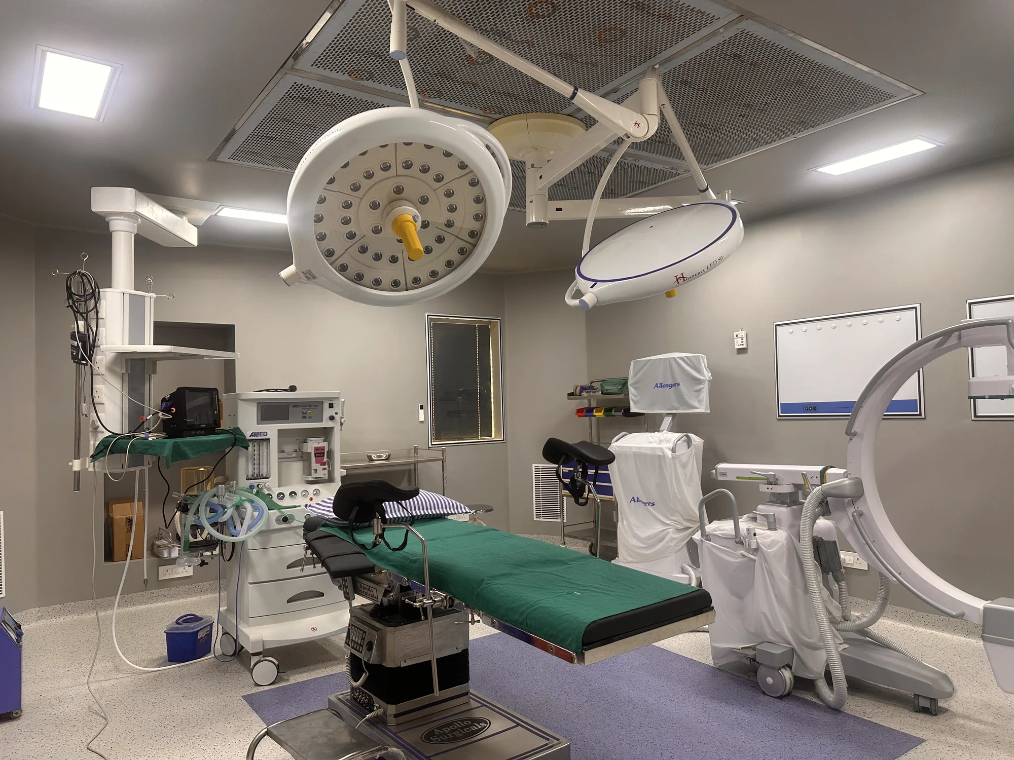Operating theatre with surgical table, overhead lights and medical equipment