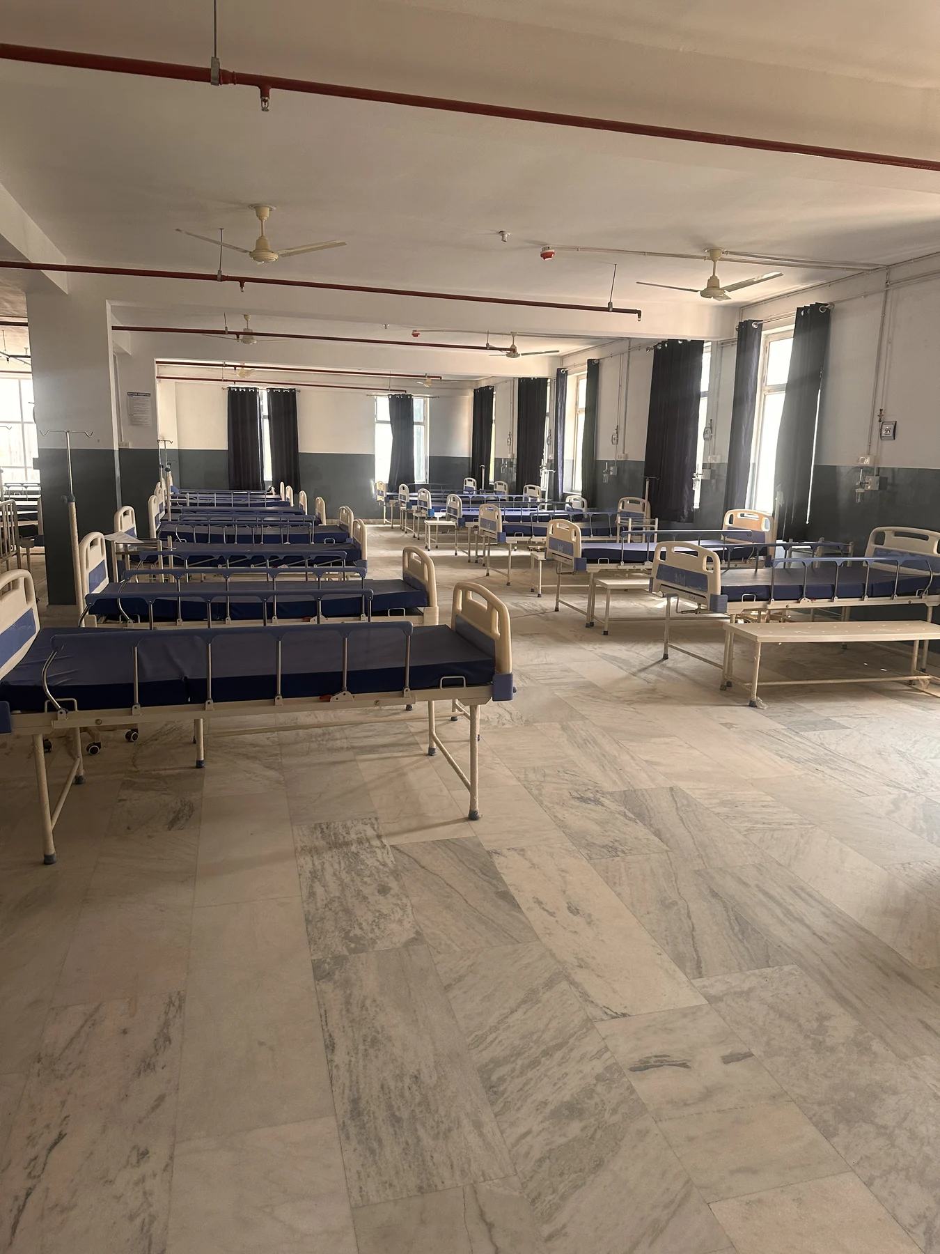 View across the inpatient ward, with patient beds and windows along the room